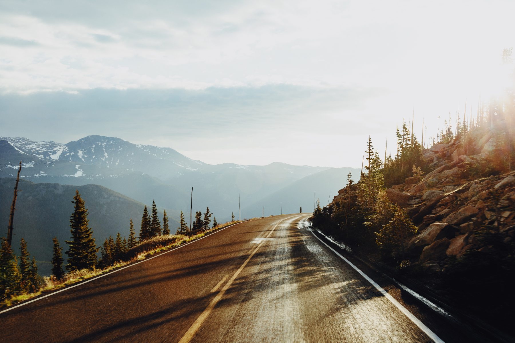 A country road winding through green hills at sunrise